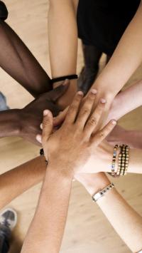 Hands stacked together in circle showing teamwork